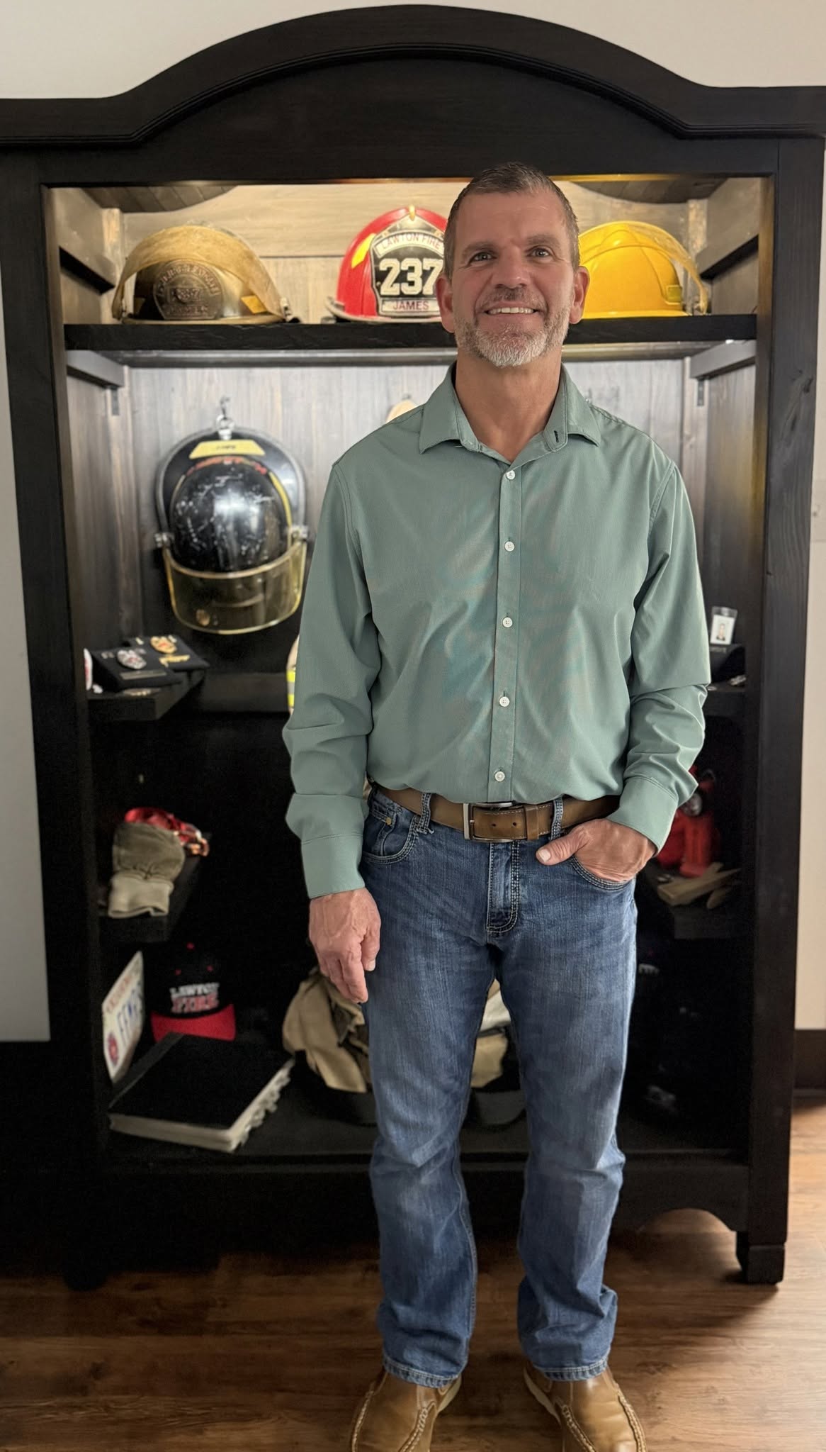 William Kent James standing beside fire helmets